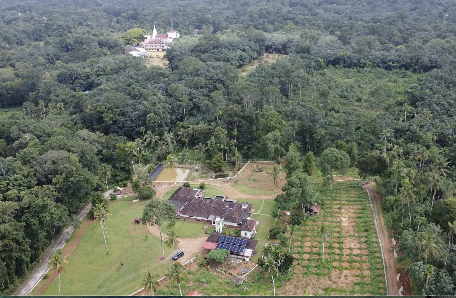 Aerial view of the Kulathamackal property with the church of Pampady in the distance